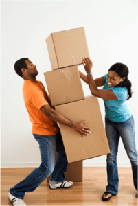 Couple carrying and stacking moving boxes