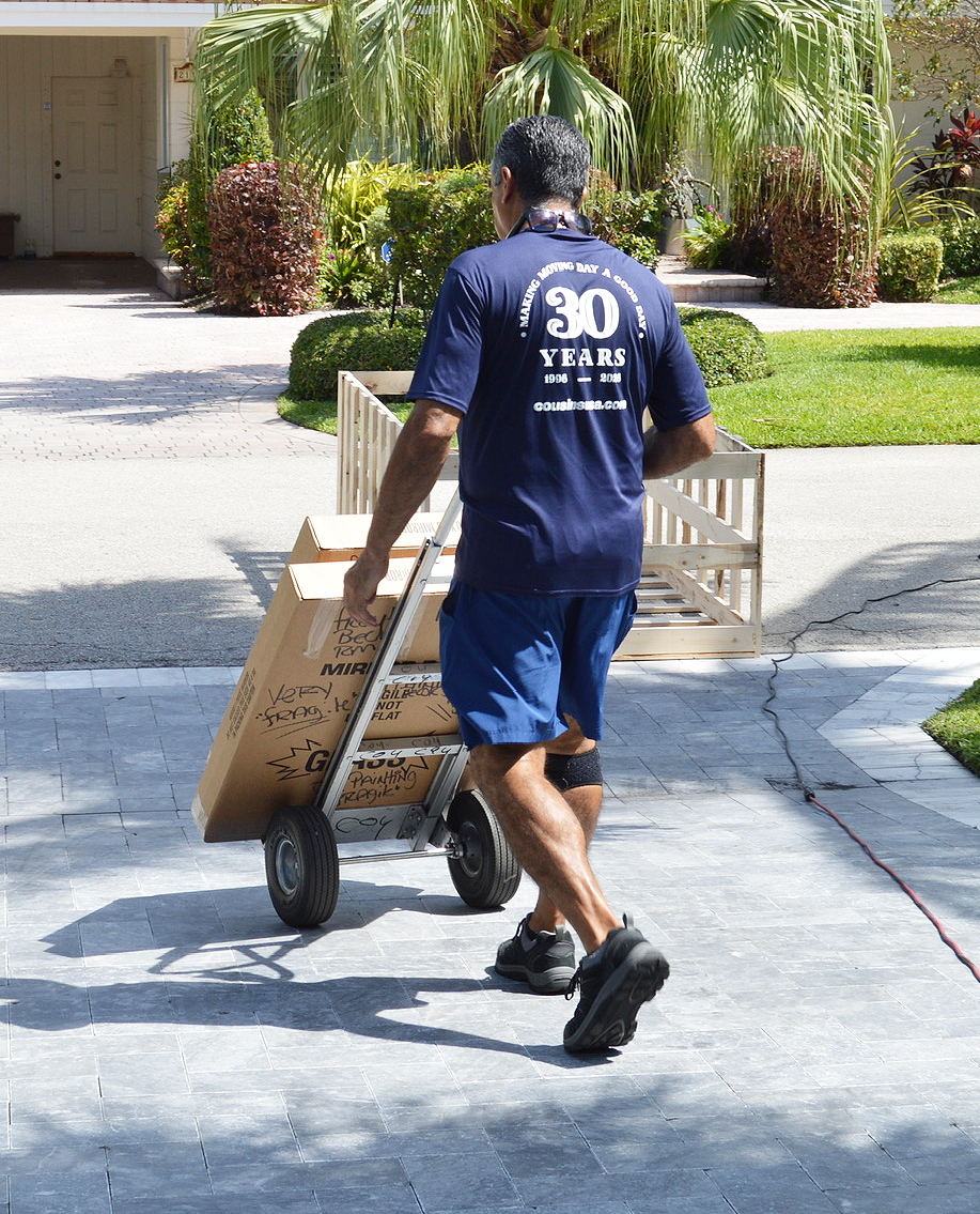 A mover with a dolly moves paintings